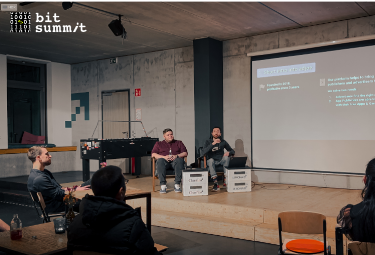 Two speakers sitting on the stage