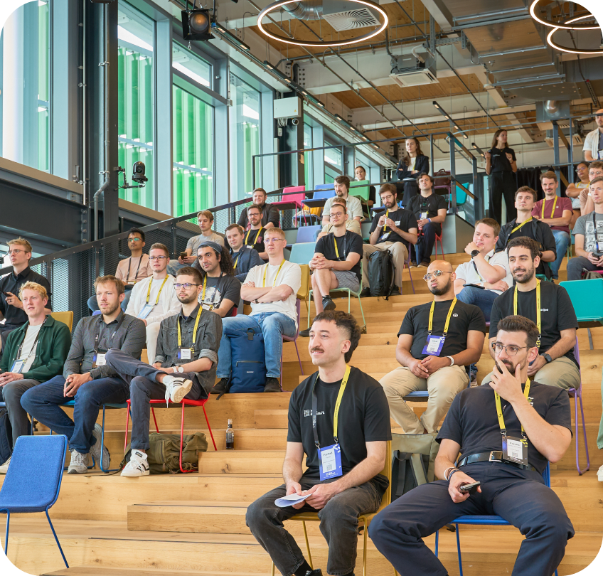 Attendees seated on wooden bleachers at Bit Summit