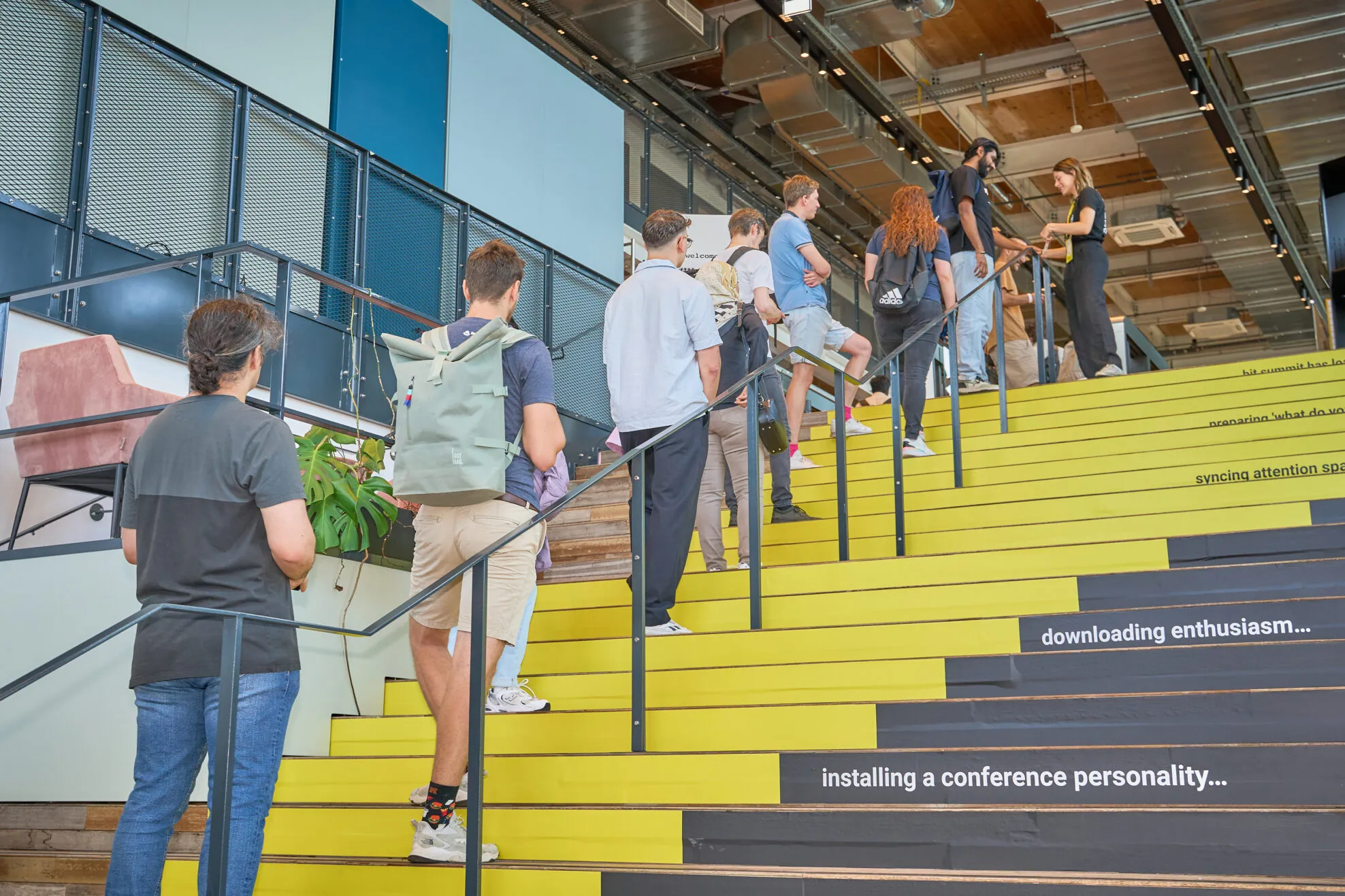 Attendees walking up yellow stairs at the venue